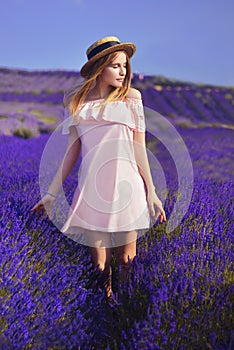 Beautiful girl on the lavender field. Beautiful woman in the lavender field on sunset. Soft focus. Provence, France. A girl in pin