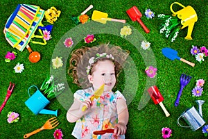 Beautiful girl on a lawn with garden tools