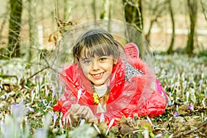 Beautiful girl laying in the flowers in the forest