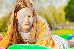 Beautiful girl laying on the lawn at sunny day