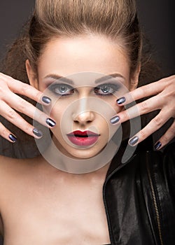 Beautiful girl in leather jacket with bright makeup and manicure Cat's Eye. Beauty face. Nail Design.