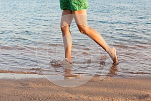 Beautiful girl legs running on the beach. pretty girl walking on water