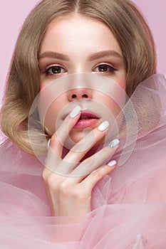 Beautiful girl with light make-up and gentle manicure in pink clothes. Beauty face. Design nails.