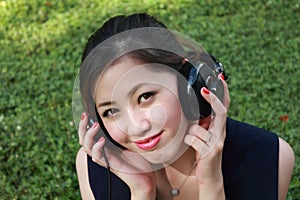 Beautiful girl listening music in the park