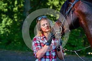 Beautiful girl with long hair on a walk with a horse.