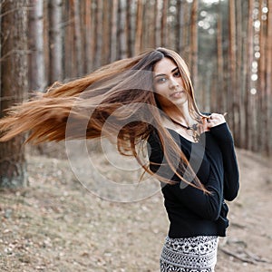 Beautiful girl with long hair walking in the park. Long Hair Blowing in the Wind