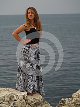 Beautiful girl in a long skirt on the stones