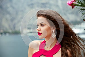 Beautiful girl with long wavy hair, red lips and fashion earring