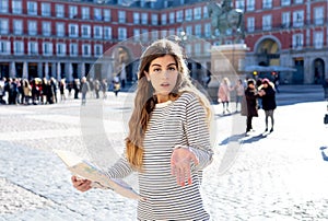 Beautiful girl looking at a map in Plaza Mayor Madrid feeling lost and looking for directions