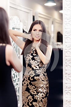 Beautiful Girl Looking in the Mirror and Trying on an Elegant Dress