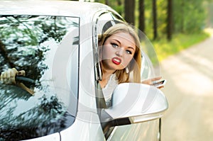 Beautiful girl looks out the car window and strongly swears