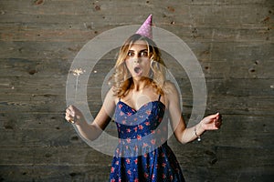 Beautiful girl looks pleasantly surprised while celebrating her birthday