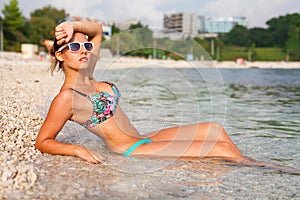 Beautiful girl lying on the coast and taking sunbath.