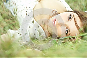 Beautiful girl lying down of grass