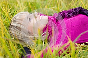 Beautiful girl lying on fall grass