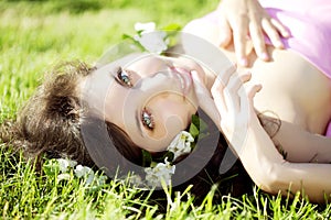 Beautiful girl lying on the grass with flowers