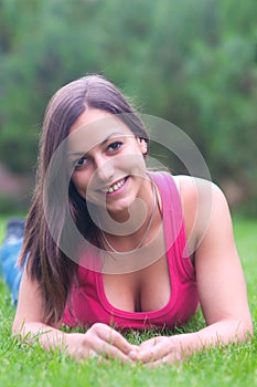 Beautiful girl lying in the grass on sunny spring day