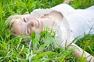 Beautiful girl is lying on green grass