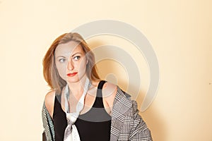 Beautiful girl with make-up in a black shirt and jacket men's tie posing