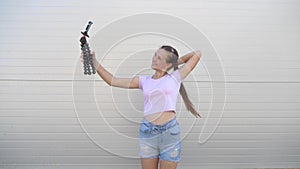 Beautiful girl makes selfie outdoors. teenager is photographed on a smartphone using small tripod. young girl blogger