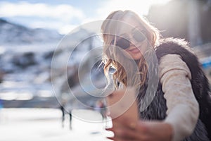 Beautiful girl making a selfie mobile phone at ice rink