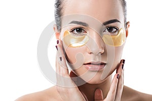 beautiful girl with moisturizing under eyes patches touching face with hands