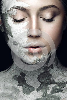 Beautiful girl with mud on his face. Cosmetic mask. Beauty face.