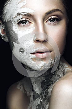 Beautiful girl with mud on his face. Cosmetic mask. Beauty face.