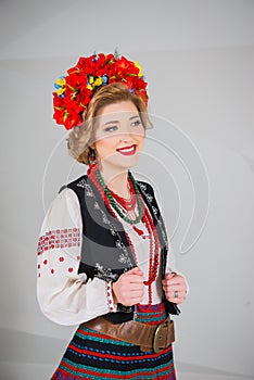 A beautiful girl in National Ukrainian Costume. captured in studio. Embroidery and jacket. wreath. circlet of flowers. red lips