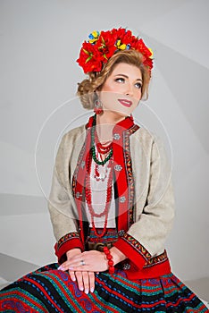 A beautiful girl in National Ukrainian Costume. captured in studio. Embroidery and jacket. wreath. circlet of flowers. red lips