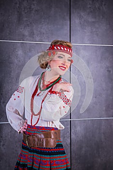 A beautiful girl in National Ukrainian Costume. captured in studio. Embroidery and jacket. wreath. circlet of flowers. red lips