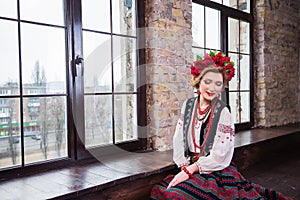 A beautiful girl in National Ukrainian Costume. captured in studio. Embroidery and jacket. wreath. circlet of flowers. red lips