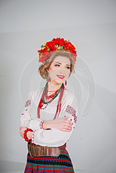 A beautiful girl in National Ukrainian Costume. captured in studio. Embroidery and jacket. wreath. circlet of flowers. red lips