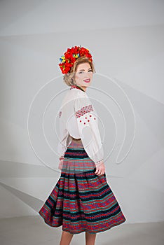 A beautiful girl in National Ukrainian Costume. captured in studio. Embroidery and jacket. wreath. circlet of flowers. red lips