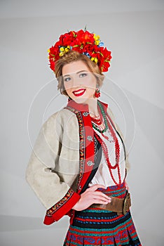 A beautiful girl in National Ukrainian Costume. captured in studio. Embroidery and jacket. wreath. circlet of flowers. red lips