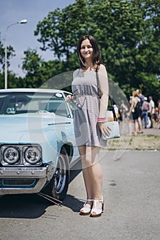 Beautiful girl near a blue muscle car