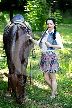 Beautiful girl near brown horse