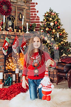 Beautiful girl near a Christmas tree with gifts