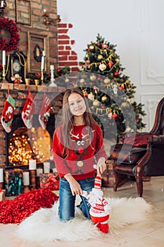 Beautiful girl near a Christmas tree with gifts