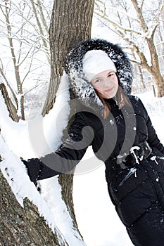 Beautiful girl near a tree in snow