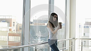 Beautiful girl near the window with a smartphone