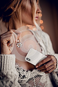 Beautiful girl with necklace and telephone on golden bokeh light