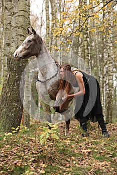 Beautiful girl with nice dress standing next to nice horse