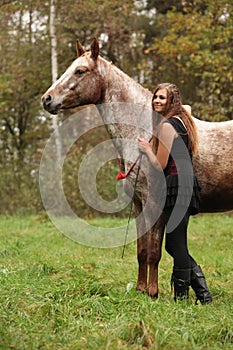 Beautiful girl with nice dress standing next to nice horse