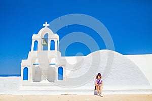 Beautiful girl in Oia village on Santorini island