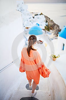 Beautiful girl in Oia village on Santorini island