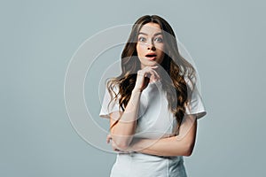 Beautiful girl with open mouth looking at camera isolated on grey