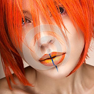 Beautiful girl in an orange wig cosplay style with bright creative lips. Art beauty image.