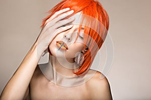 Beautiful girl in an orange wig cosplay style with bright creative lips. Art beauty image.