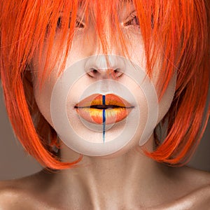 Beautiful girl in an orange wig cosplay style with bright creative lips. Art beauty image.